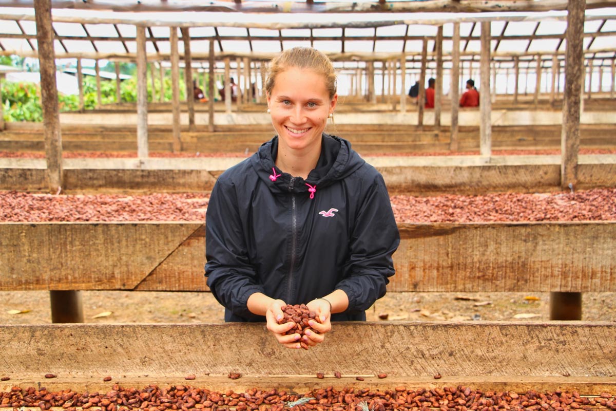 Amandine Laridon sélectionnant des fèves de cacao sur les bancs de séchage en Côte d'Ivoire